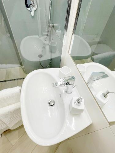 a white bathroom with a sink and a shower at B&B Vittoria in Anzio