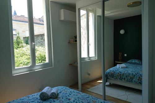 1 dormitorio con espejo, cama y espejo en T2 calme et design quartier Chartrons à Bordeaux en Burdeos