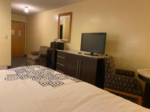 a hotel room with a bed and a flat screen tv at Knights Inn & Suites Dublin in Dublin
