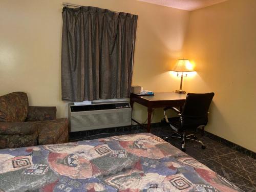 a hotel room with a bed and a desk and a window at Knights Inn & Suites Dublin in Dublin