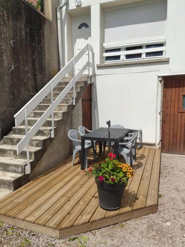 a wooden deck with a table and a potted plant at Appartement au centre du tholy pour 5 personnes maximum in Le Tholy