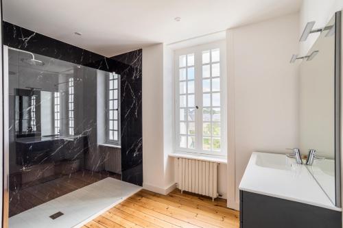 y baño con ducha de mármol negro y lavabo. en La Villa Souhaitier en Saint-Malo