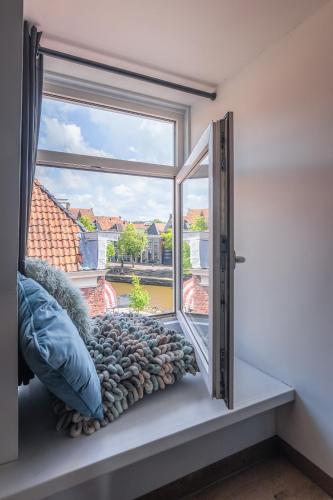 a window with a view of a house at Hotel Café Restaurant 't Raedhûs in Dokkum