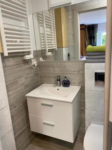a bathroom with a white sink and a mirror at Secret Garden by Arder in Gdynia