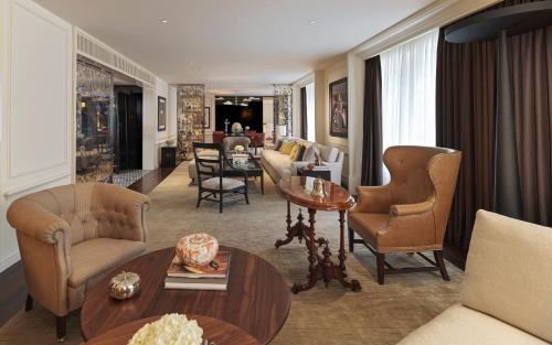 uma sala de estar com um sofá, cadeiras e uma mesa em Rosewood London em Londres