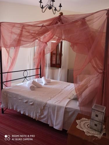 a bedroom with a bed with a pink canopy at Lefkara Hotel in Pano Lefkara
