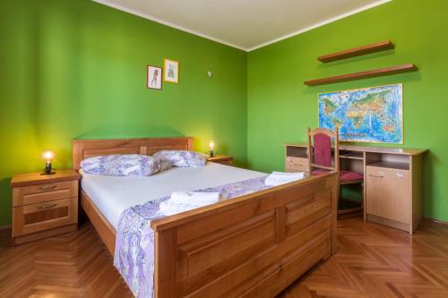 1 dormitorio con 1 cama con pared verde en Lovely House LINDI in Poreč, en Poreč