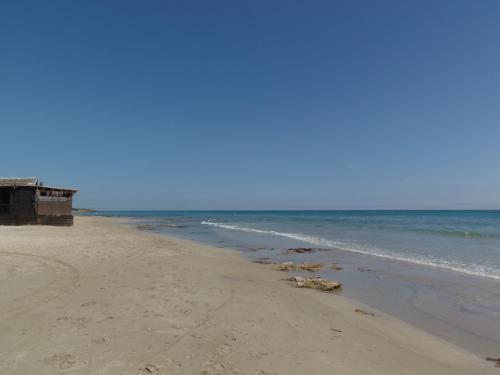 a beach with a house and the ocean at Missipezza Residence a Frassanito in Alimini