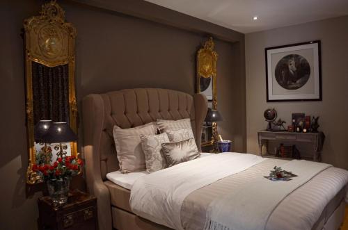 a bedroom with a large bed with a gold frame at La Maison Des Papillons in Deerlijk