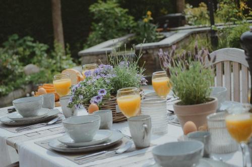a table with eggs and glasses of orange juice at La Maison Des Papillons in Deerlijk