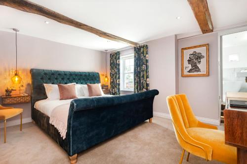 1 dormitorio con 1 cama grande y cabecero azul en The Queen's Inn, en Hawkhurst