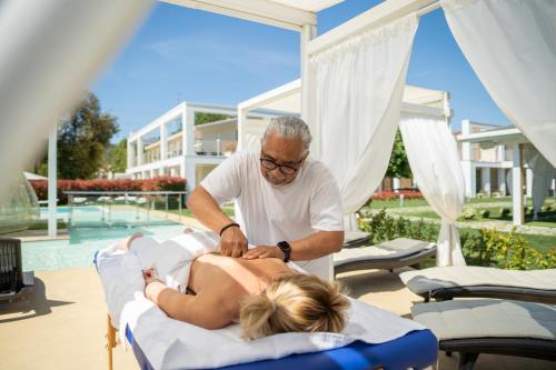 Un hombre está cortando a una mujer en una cama en iConic Wellness Resort & Spa, en Arezzo