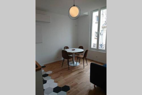 een eetkamer met een tafel en stoelen en een raam bij appartement 4 pers quartier Chartrons à Bordeaux in Bordeaux