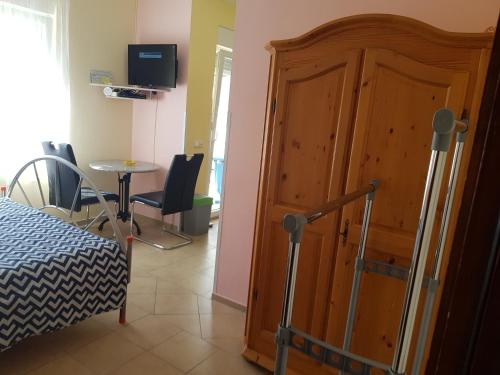 een slaapkamer met een houten deur en een tafel en stoel bij Hana in Umag