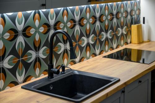 un lavandino in una cucina con una parete decorata di Edelin Cottage a Edelény