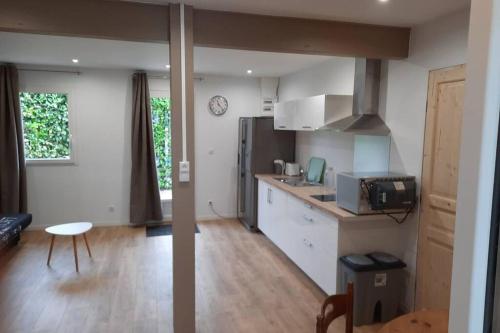 cocina y sala de estar con mesa y nevera en studio rdc avec terrasse, en Rang-du-Fliers