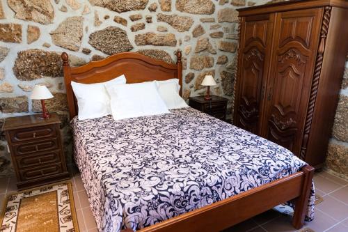 a bedroom with a bed and a stone wall at Idyllic Villa in Fornos + Pool! in Fornos