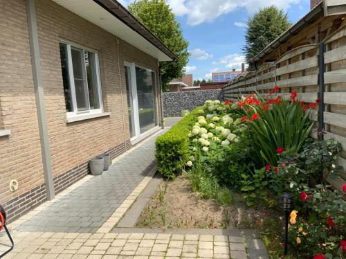 a garden outside of a house with flowers at LinZn vakantiehuis in Wuustwezel