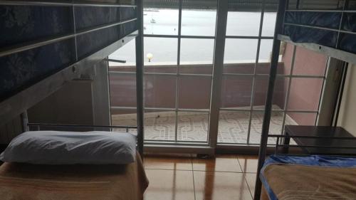 1 dormitorio con 2 literas y ventana grande en Albergue en Corcubion playa de Quenxe en Corcubión