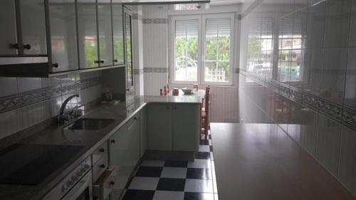 a kitchen with a black and white checkered floor at Albergue en Corcubion playa de Quenxe in Corcubión