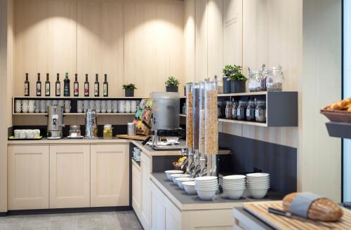 a kitchen with a counter with dishes and wine bottles at JUFA Hotel Laterns - Klangholzhus in Laterns