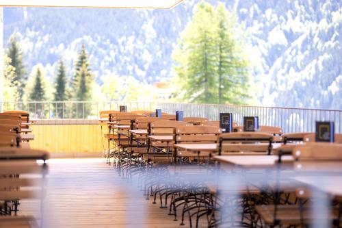 a row of tables and chairs with mountains in the background at JUFA Hotel Laterns - Klangholzhus in Laterns
