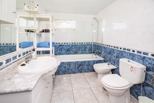 een blauwe en witte badkamer met een toilet en een wastafel bij Lanzahost Apartamento LARIMAR in Costa Teguise