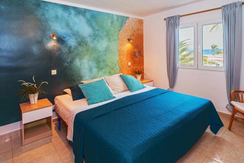 een slaapkamer met een bed met een blauw dekbed bij Lanzahost Apartamento LARIMAR in Costa Teguise