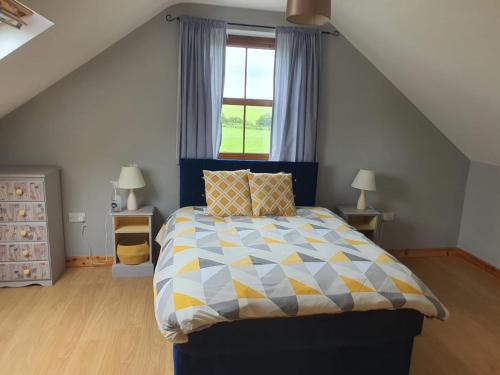 a bedroom with a bed with a blue and yellow comforter at Murphys Irish Farmhouse in Tralee