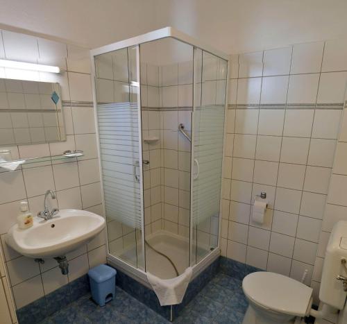 y baño con ducha, lavabo y aseo. en Corvin Hotel en Győr