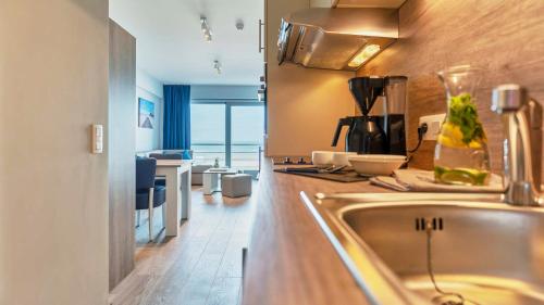 a kitchen with a sink and a counter top at Holiday Suites Blankenberge in Blankenberge