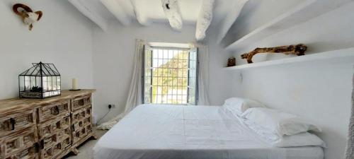 a white bedroom with a large bed and a window at Elysium - a romantic escape in Mojacar Pueblo in Mojácar