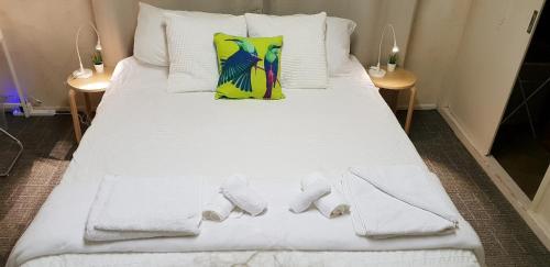 a bed with white sheets and towels on it at WOODY Pt - AMAZING 1970's SHARE HOUSE BY THE SEA-4 rooms available! in Woody Point