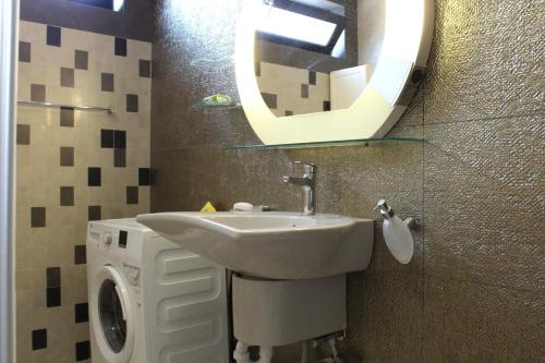 un bagno con un lavandino e uno specchio sul muro di Villa Čengić a Sarajevo