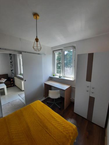 a bedroom with a bed and a desk and a window at Apartament Zorzy przy Instytucie Kardiologii Anin in Warsaw