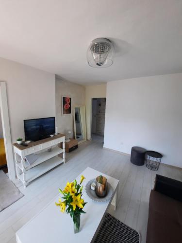 a living room with a vase of flowers on a table at Apartament Zorzy przy Instytucie Kardiologii Anin in Warsaw