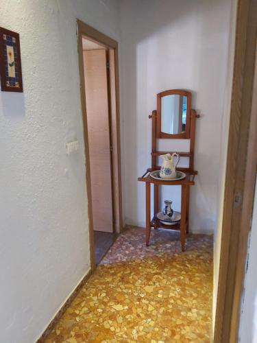 a hallway with a table and a mirror and a table with a chair at Los Duendes in El Puerto de Santa María