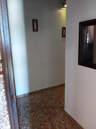 a room with a white wall and a mirror at Los Duendes in El Puerto de Santa María