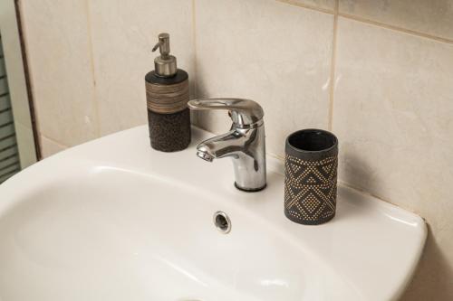 a sink with a faucet and a cup on it at Narkissos 'SUPERB' in Chania Town