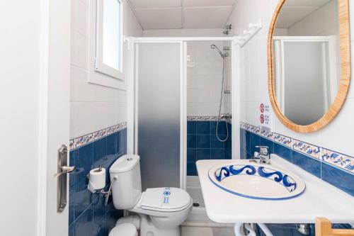 a bathroom with a toilet and a sink and a mirror at Hostal El Alférez in El Palmar