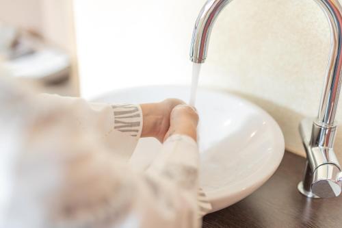 a person washing their hands in a sink at Landhaus Fiegl in Sölden