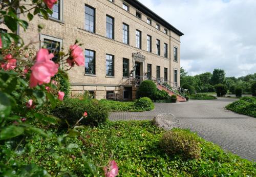 a large brick building with flowers in front of it at Gutshaus Redewisch Hotel & Restaurant in Boltenhagen
