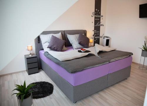 Bett in einem Zimmer mit einem lila Bettüberwurf in der Unterkunft Ferienhaus Pusteblume in Freyung
