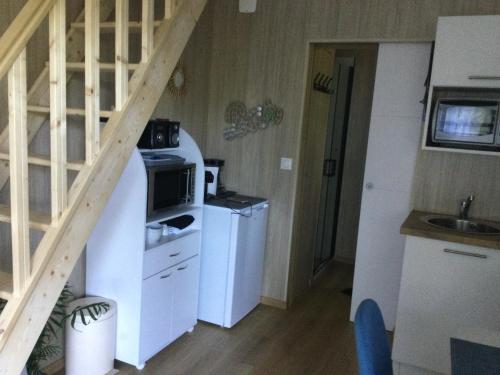 a small kitchen with white appliances and a staircase at Gîte le Pieraline in Ventron