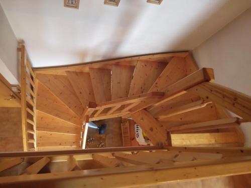 an attic room with wooden ceilings and wooden stairs at La casa di Grace nella valle incantantata in Carano