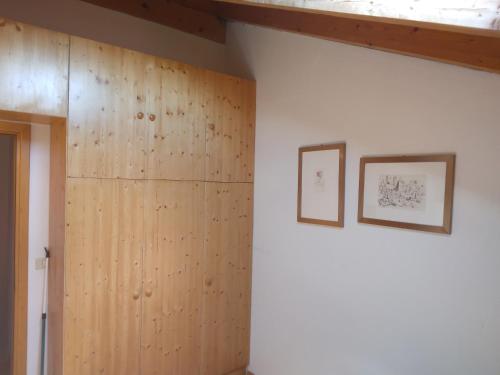 a room with wood paneling and two pictures on the wall at La casa di Grace nella valle incantantata in Carano