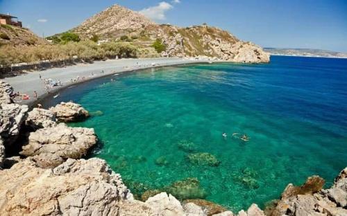 a beach with people swimming in the water at Beach Studio apartment 3, Komi in Chios
