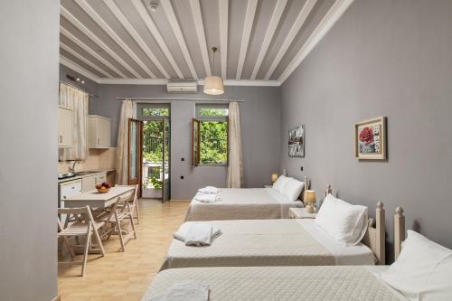 a room with four beds and a table and a kitchen at Narkissos 'SUPERB' in Chania Town