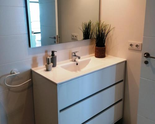 a bathroom with a sink and a mirror at Edificio Calpemar in Calpe