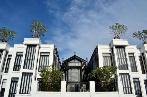 a row of white buildings with trees on top at The Siam in Bangkok